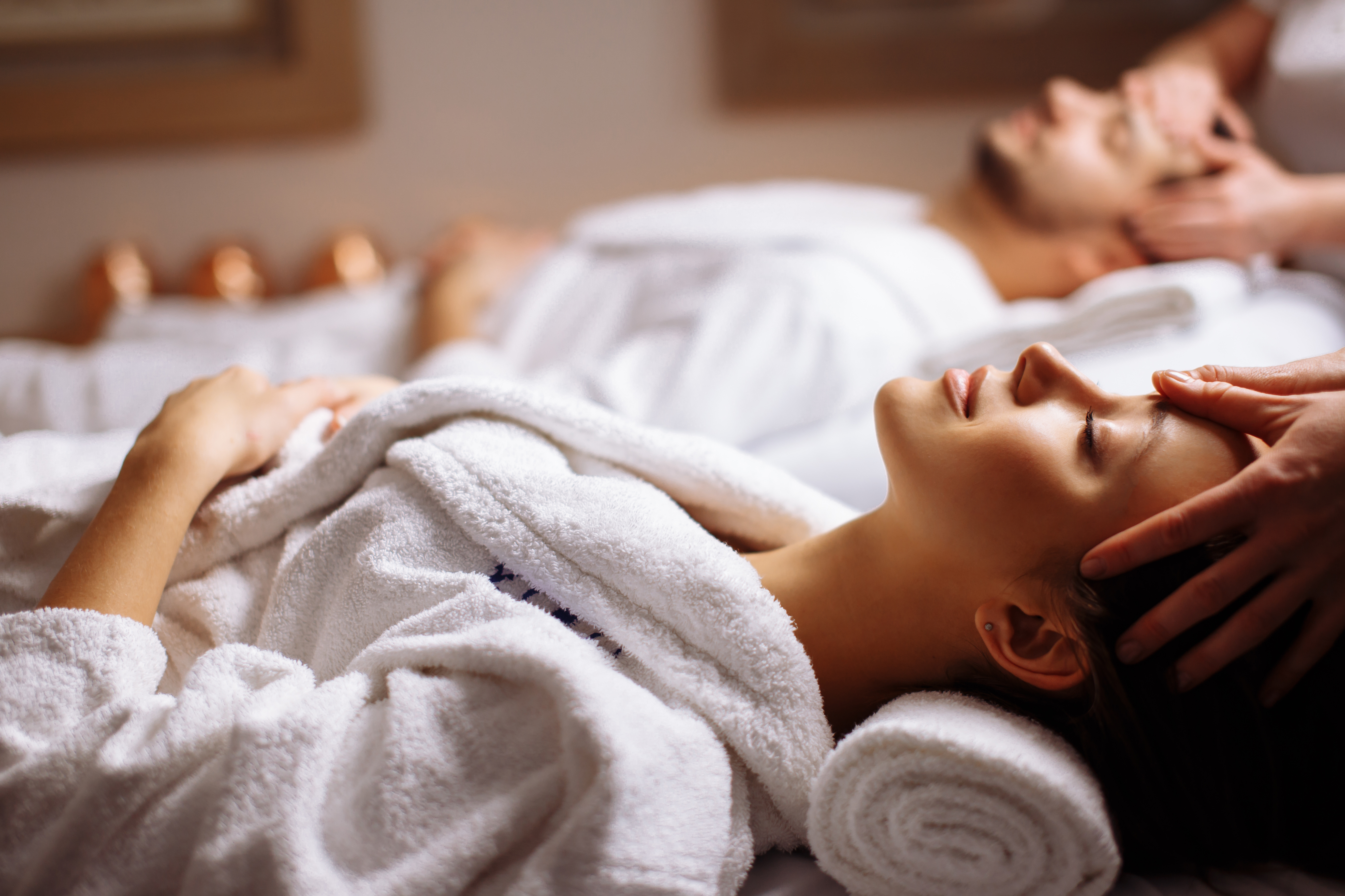 woman and man both laying on individual massage tables, both getting a massage